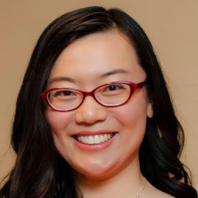 Beth Xie, a smiling young asian woman with long hair and red glasses