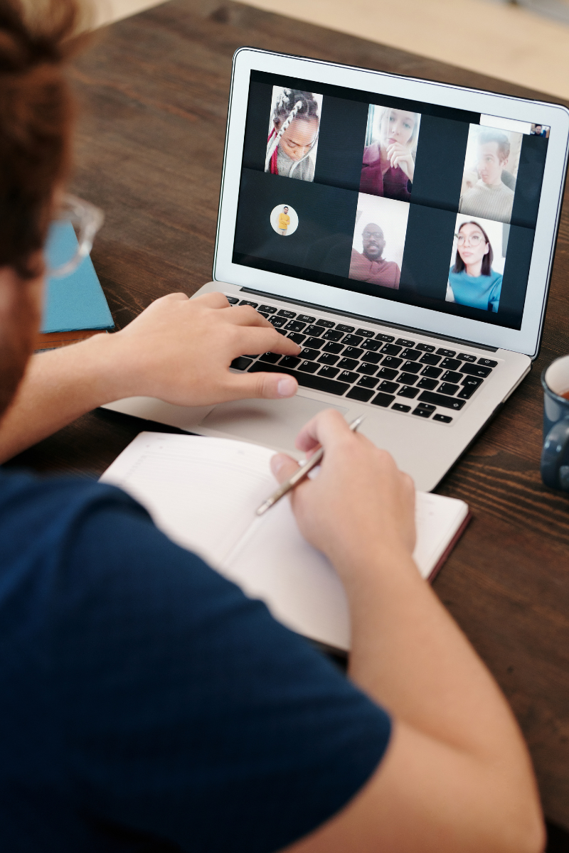 person at a laptop showing a virtual meeting