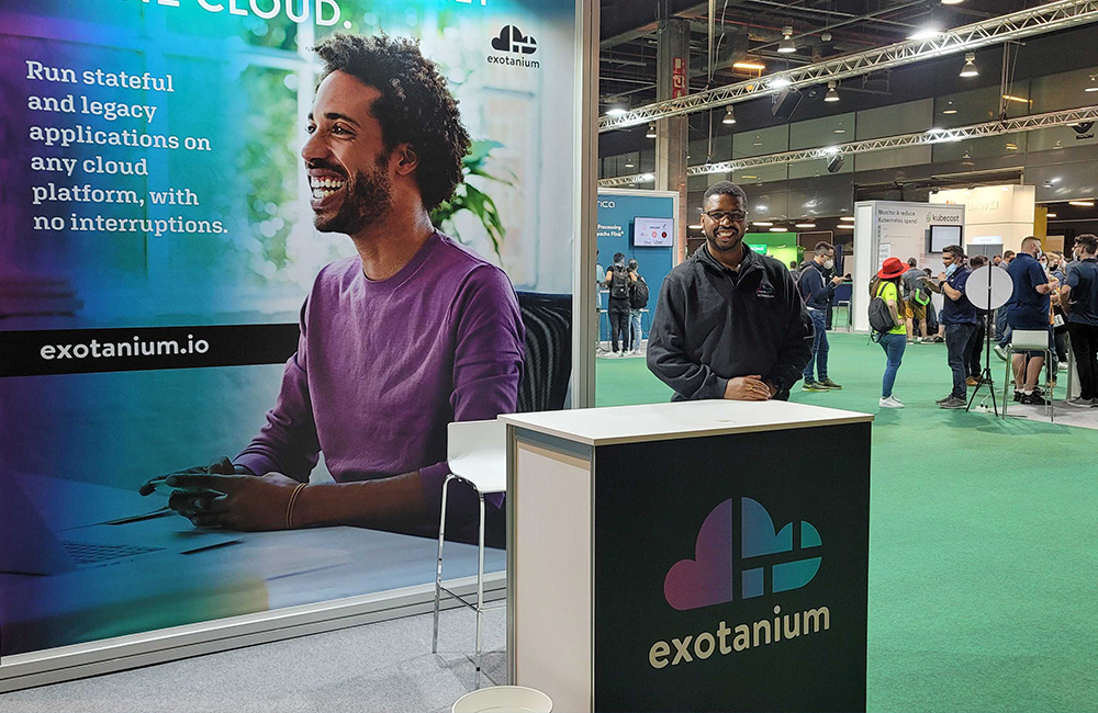 Hakim Weatherspoon, CEO and co-founder of Exotanium, stands at a conference booth with the Exotanium logo.