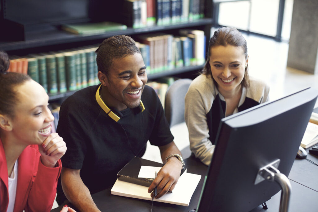 Three people working at a computer